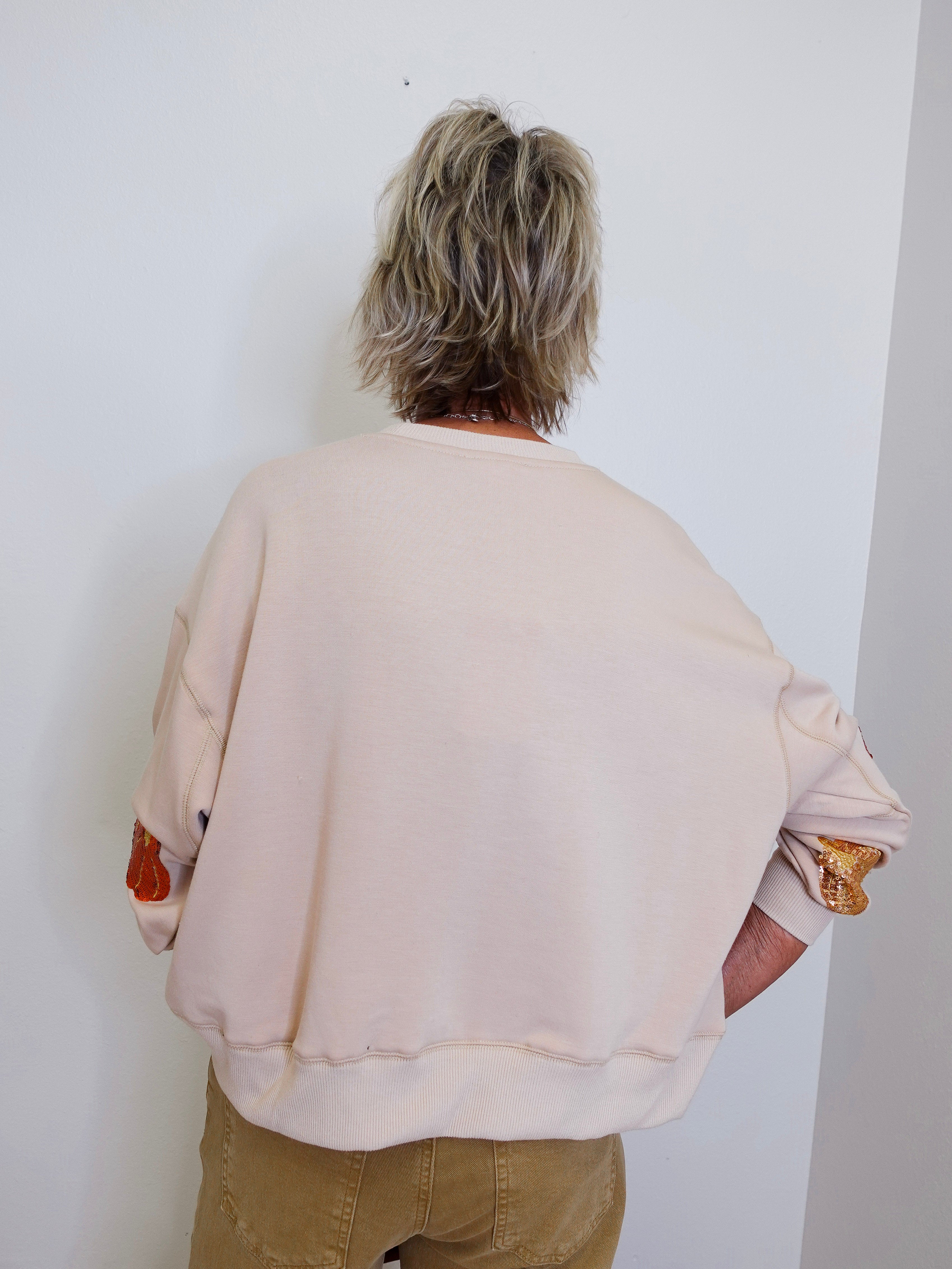 woman wearing a pumpkin sequin sweatshirt