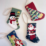 Four colorful Christmas stockings with festive designs on a white background