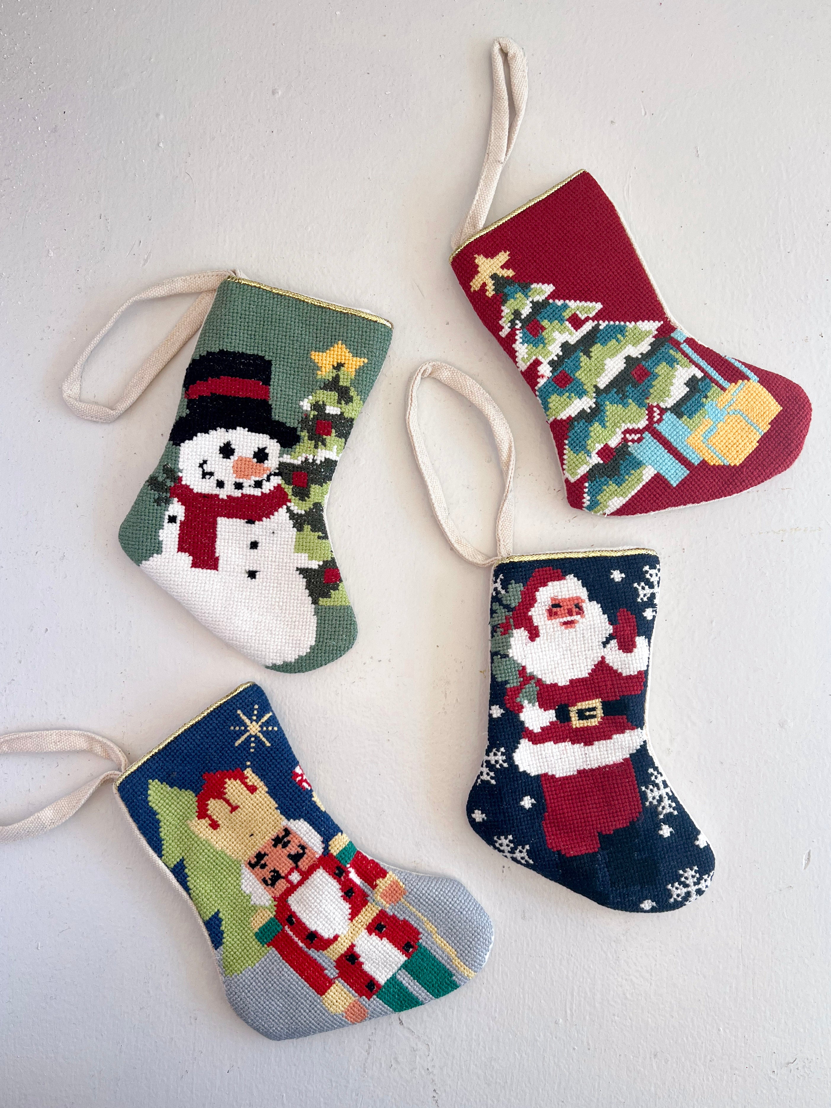 Four colorful Christmas stockings with festive designs on a white background