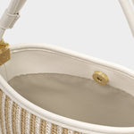Close-up of a handbag with beige interior and woven texture.