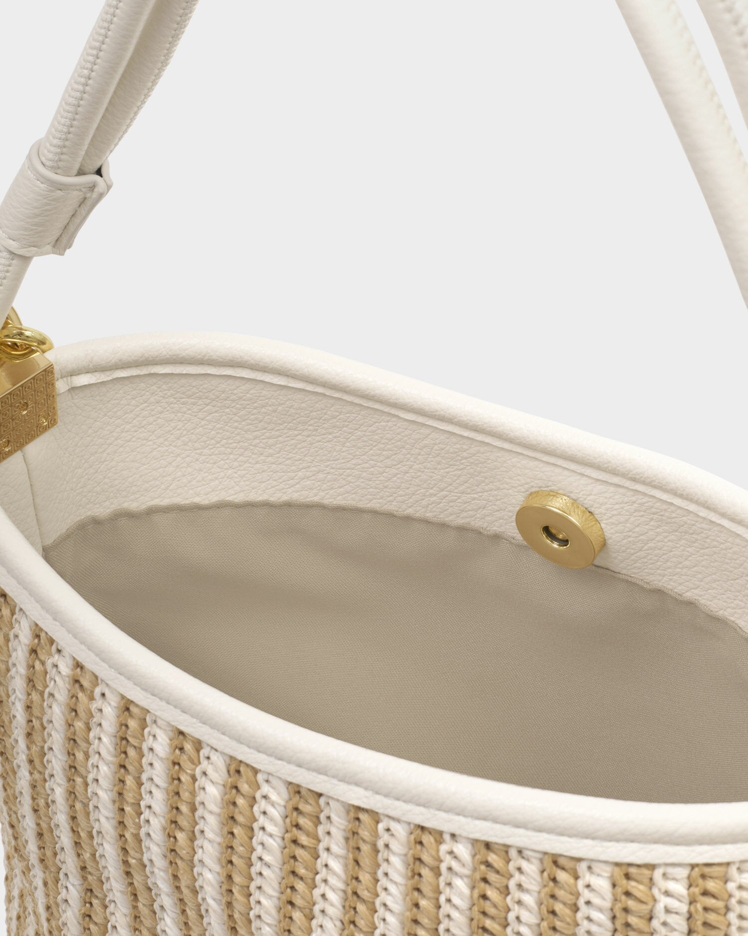 Close-up of a handbag with beige interior and woven texture.