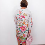 Person wearing a floral dress with a white background