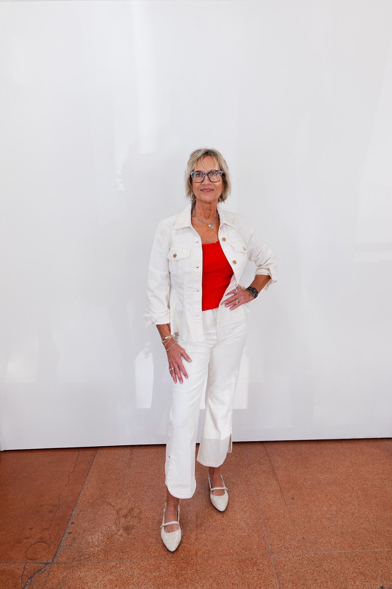 Woman in a white outfit with a red top against a white background