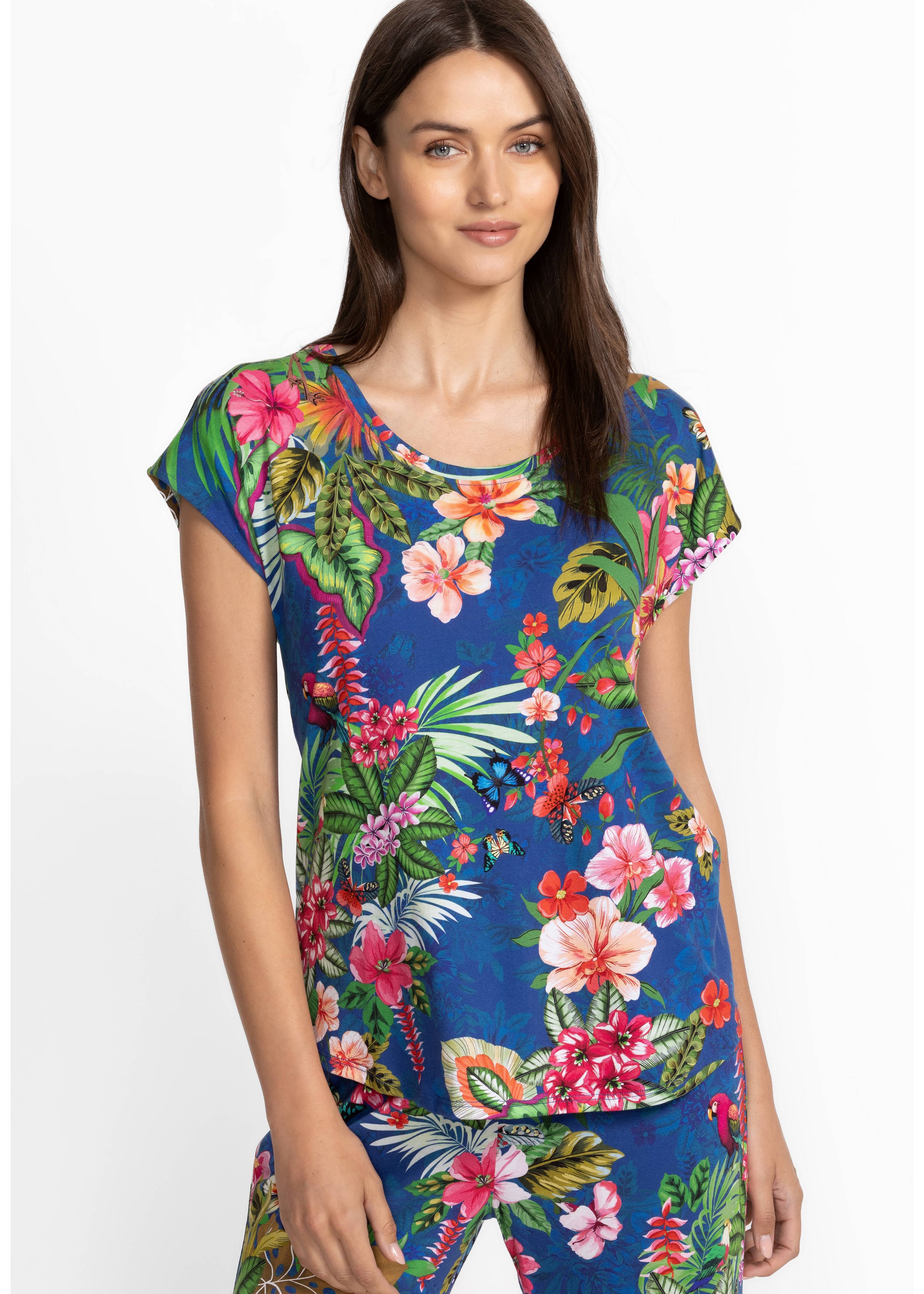 Woman wearing a colorful tropical floral pajamas on a white background