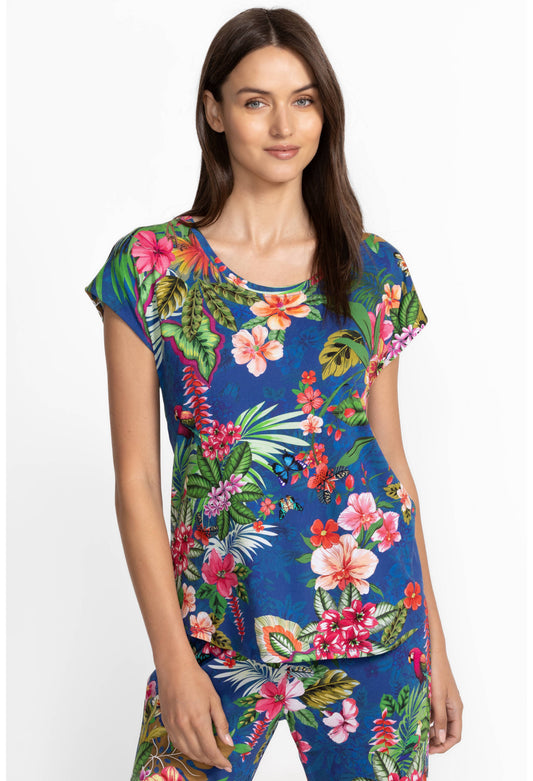 Woman wearing a colorful tropical floral pajamas on a white background