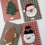 Four Christmas-themed embroidered patches on plaid backgrounds.