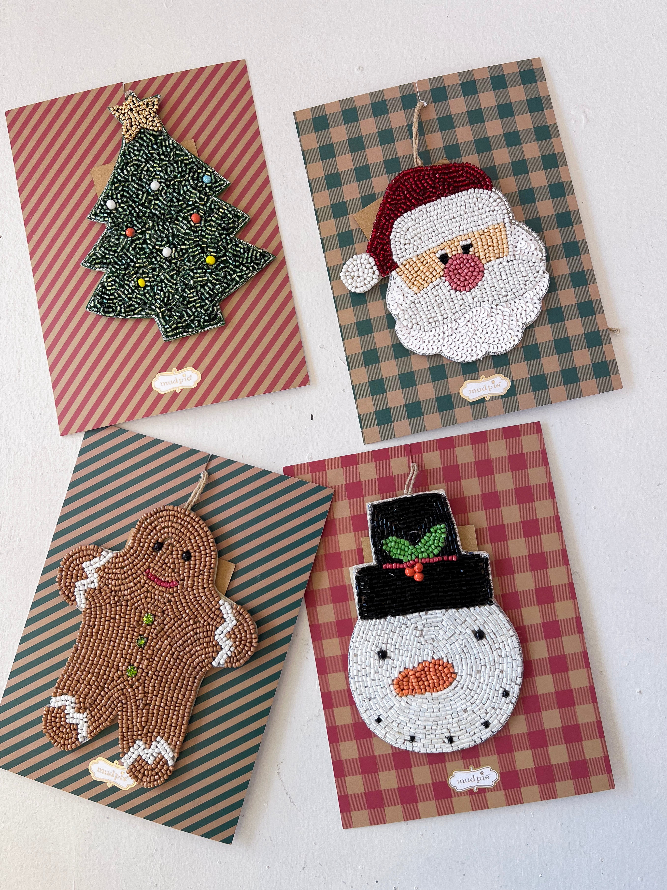 Four Christmas-themed embroidered patches on plaid backgrounds.