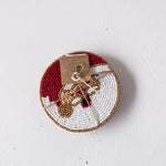 Decorative plate with beaded edge and small figurine on a white background