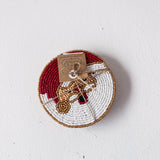 Decorative plate with beaded edge and small figurine on a white background