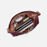 Open maroon leather pouch with gold zipper details on a white background