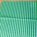 Green and light blue striped fabric on a wooden surface