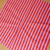 Red and pink striped fabric on a wooden surface