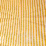 Yellow and white striped fabric on a wooden surface