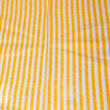 Yellow and white striped fabric on a wooden surface