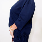Navy blue ribbed sweater worn by a person on a white background