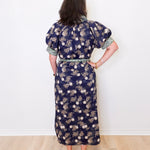 Woman wearing a floral dress with a white wall background