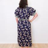 Woman wearing a floral dress with a white wall background