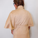 Person wearing a beige caplet top against a white background