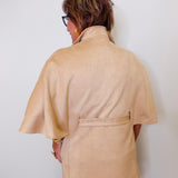 Person wearing a beige caplet top against a white background