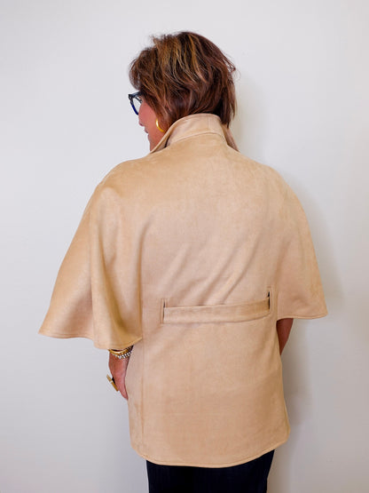 Person wearing a beige caplet top against a white background