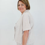 Woman wearing a light-colored outfit with a white background