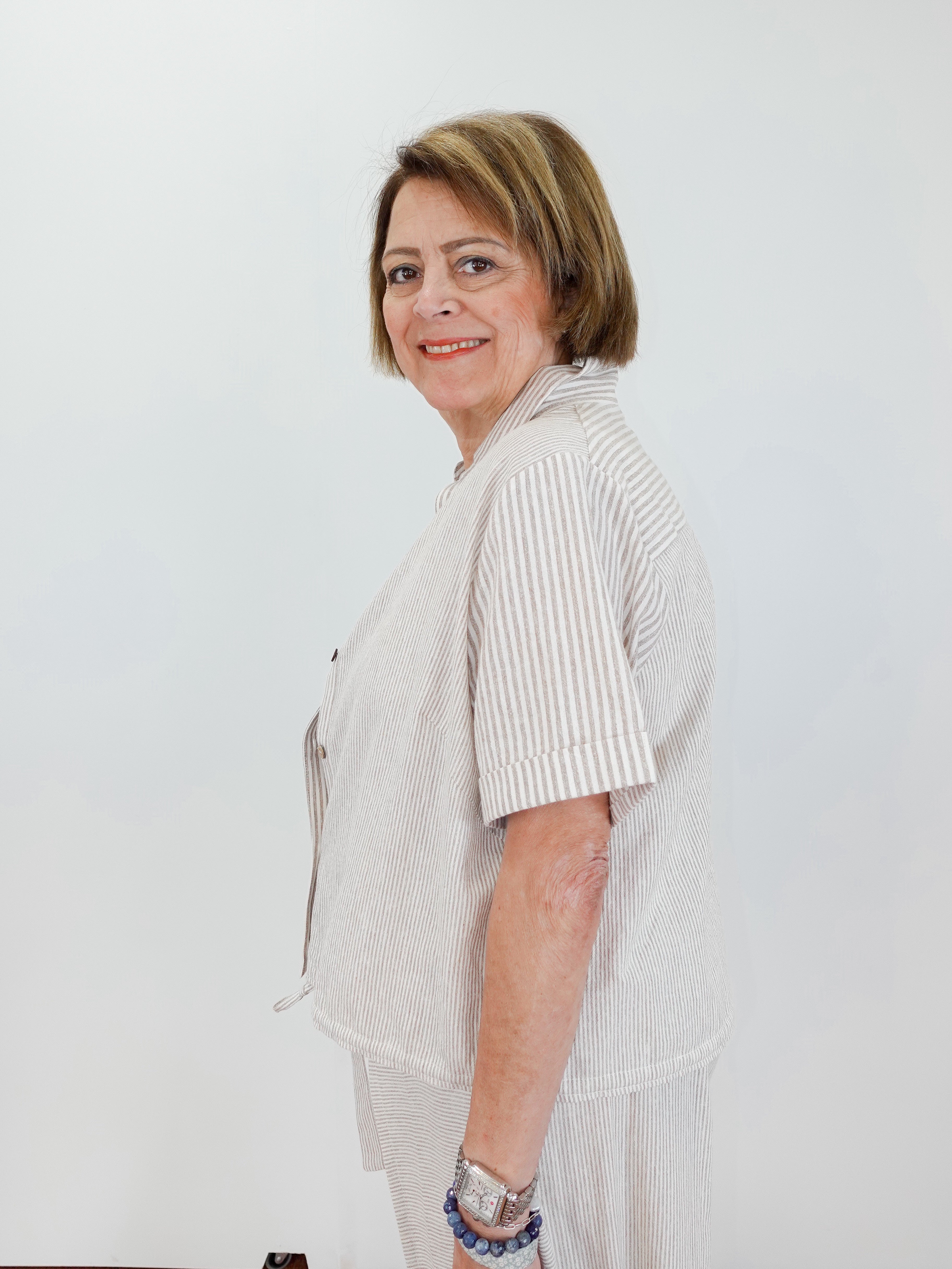 Woman wearing a light-colored outfit with a white background