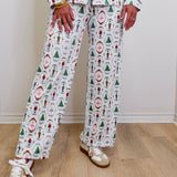 Person wearing a festive pajama set with various patterns on a wooden floor.