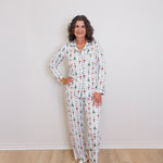 Woman wearing a patterned pajama set against a white wall.