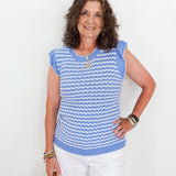 Woman wearing a blue and white striped sleeveless top against a white background