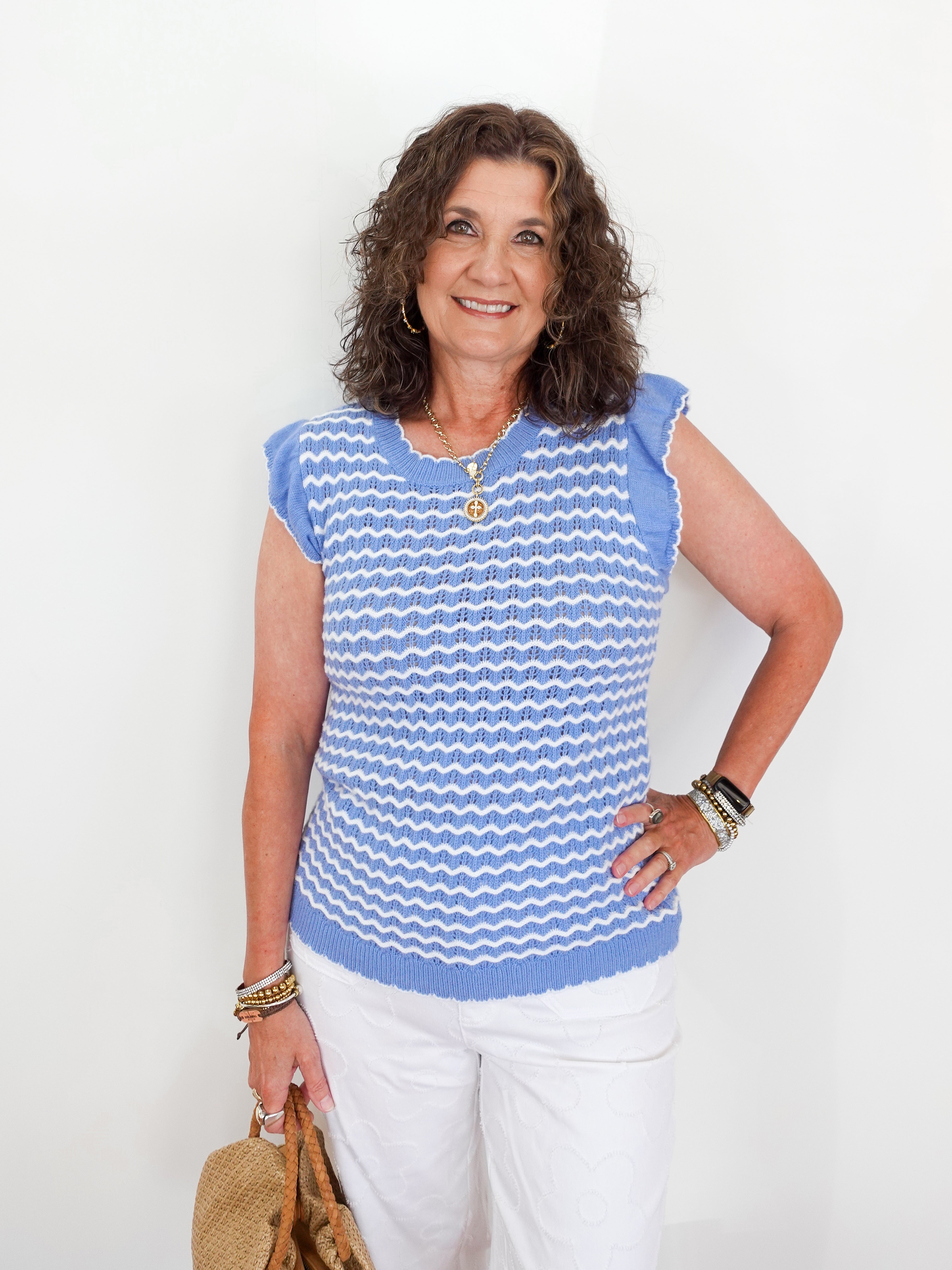 Woman wearing a blue and white striped sleeveless top against a white background