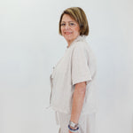 Woman wearing a light-colored outfit with a white background