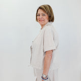 Woman wearing a light-colored outfit with a white background