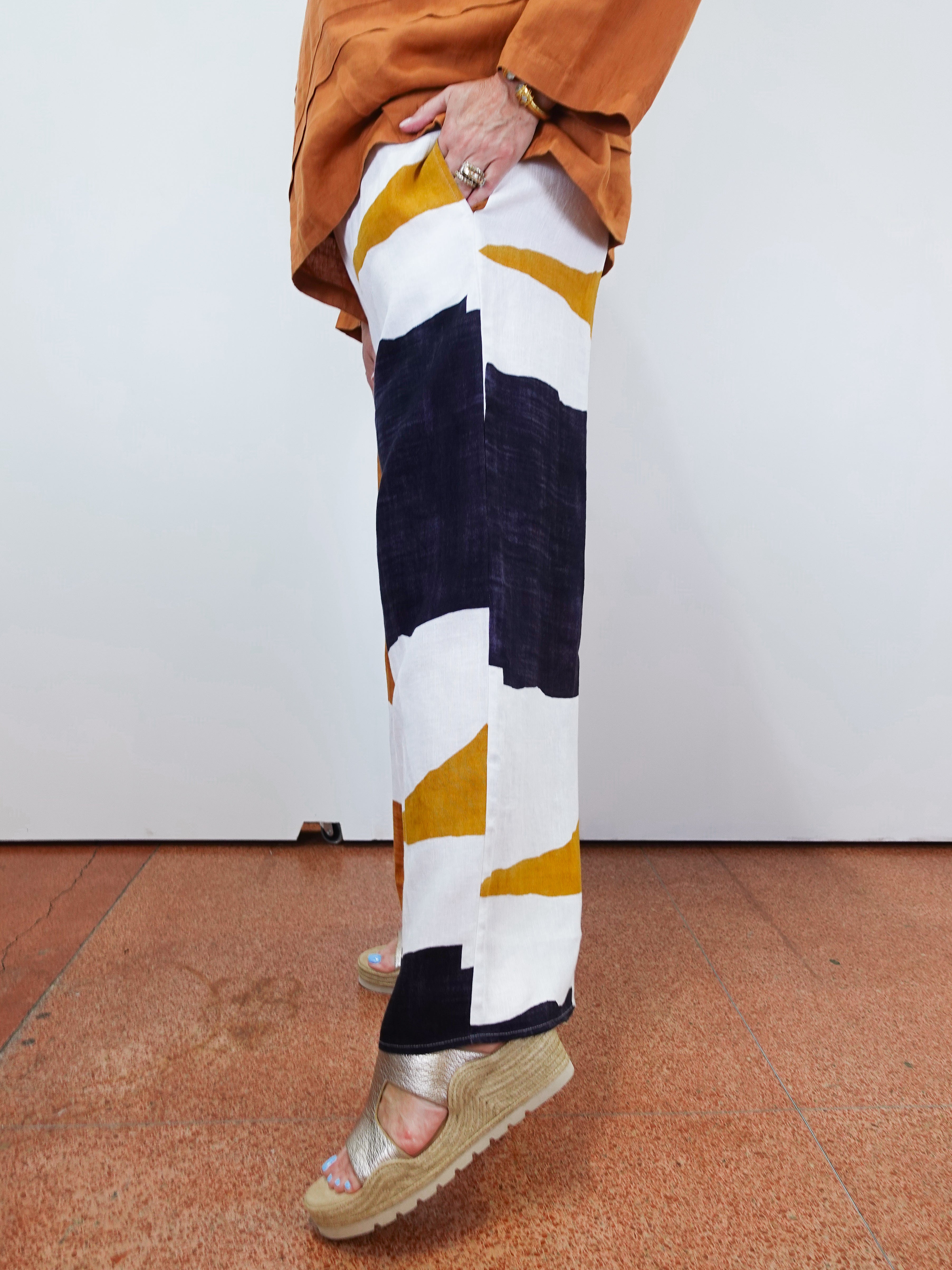 Person wearing a patterned legging with geometric design on a plain background