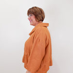 Person wearing an orange jacket against a white background