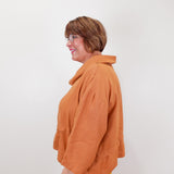 Person wearing an orange jacket against a white background