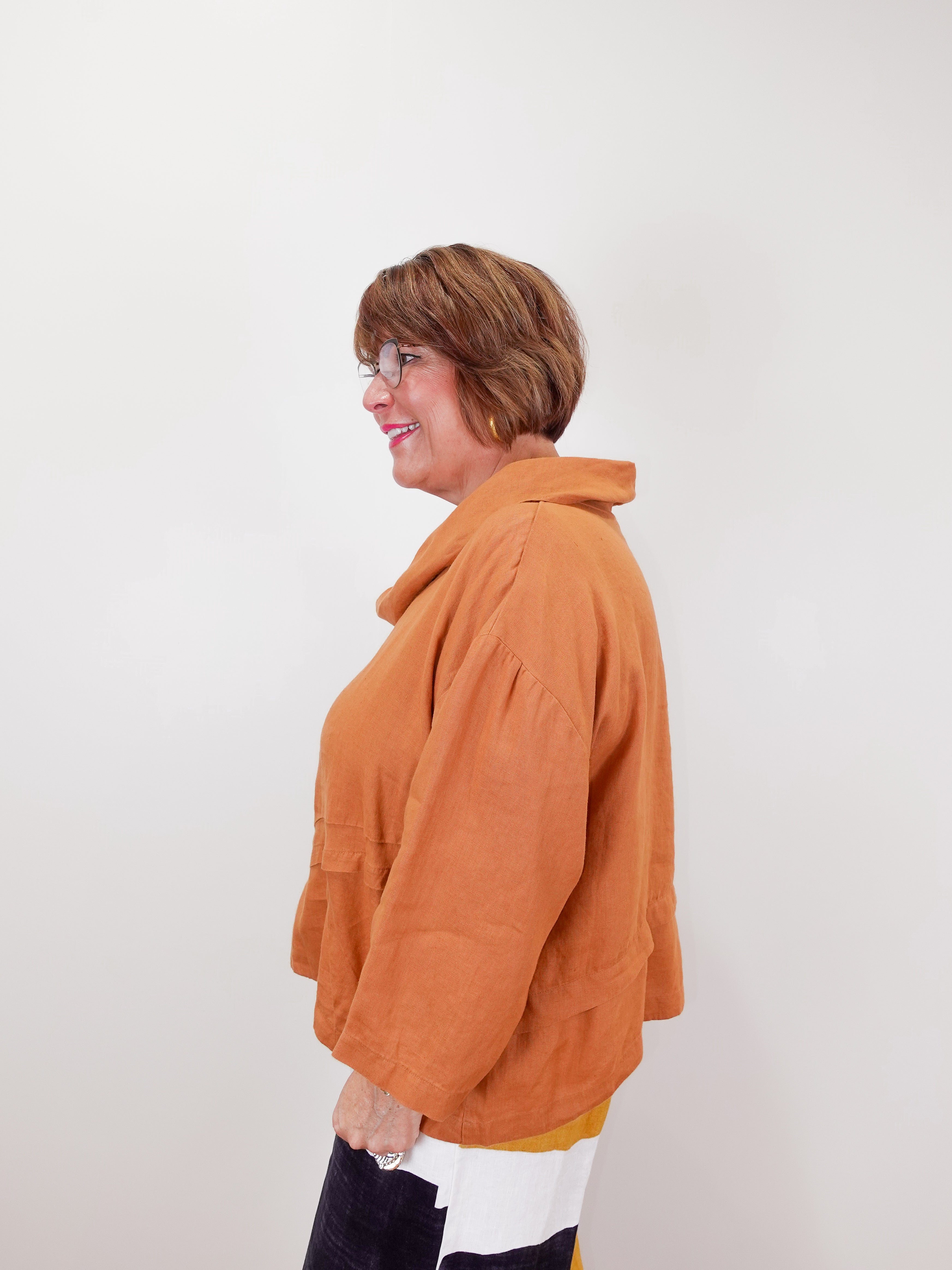 Person wearing an orange jacket against a white background