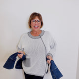 Woman holding denim jackets against a white background