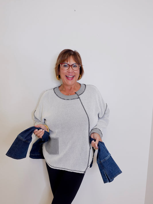 Woman holding denim jackets against a white background