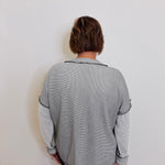 Person wearing a gray sweater against a white background