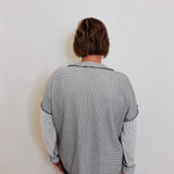 Person wearing a gray sweater against a white background