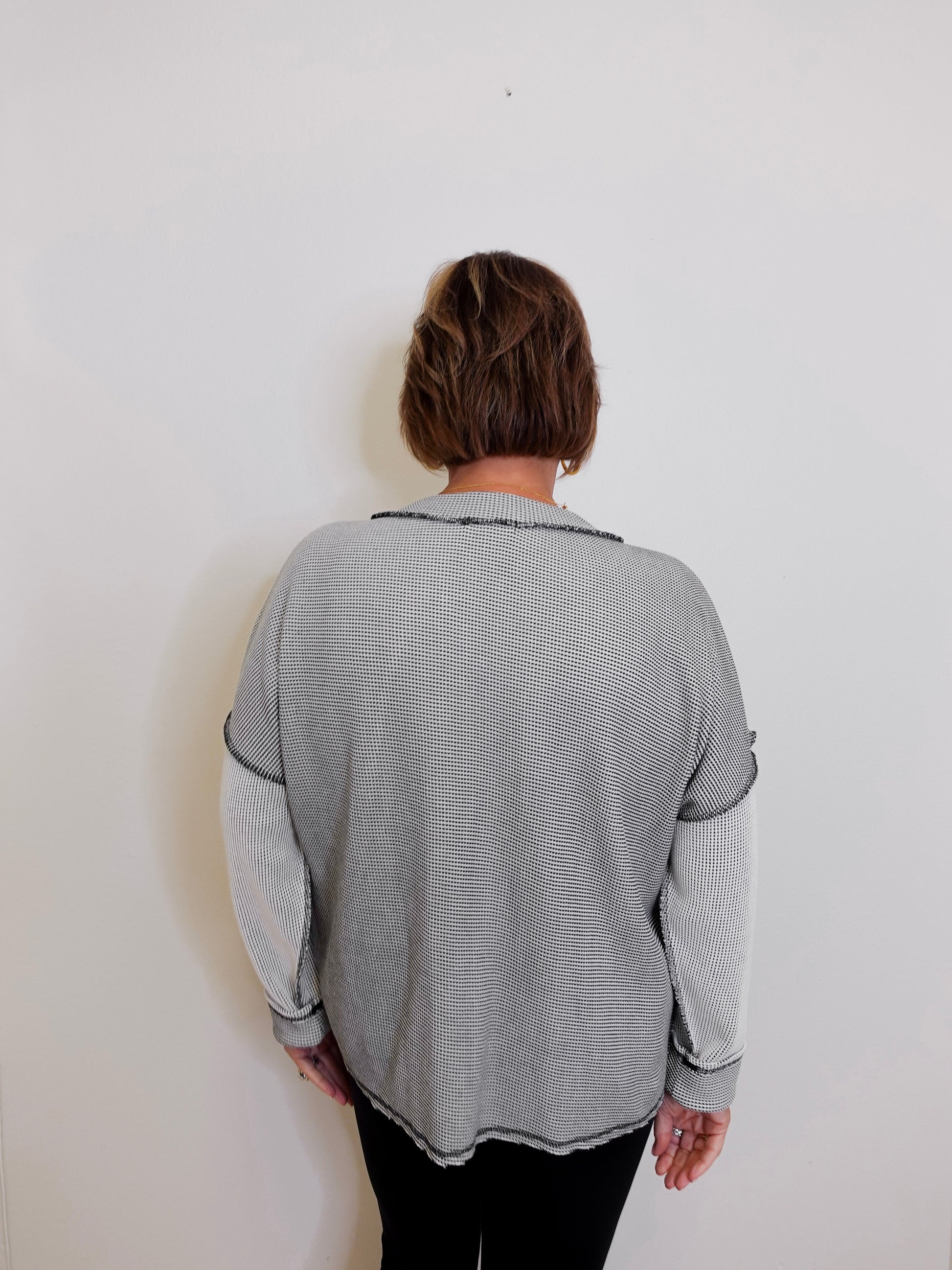 Person wearing a gray sweater against a white background