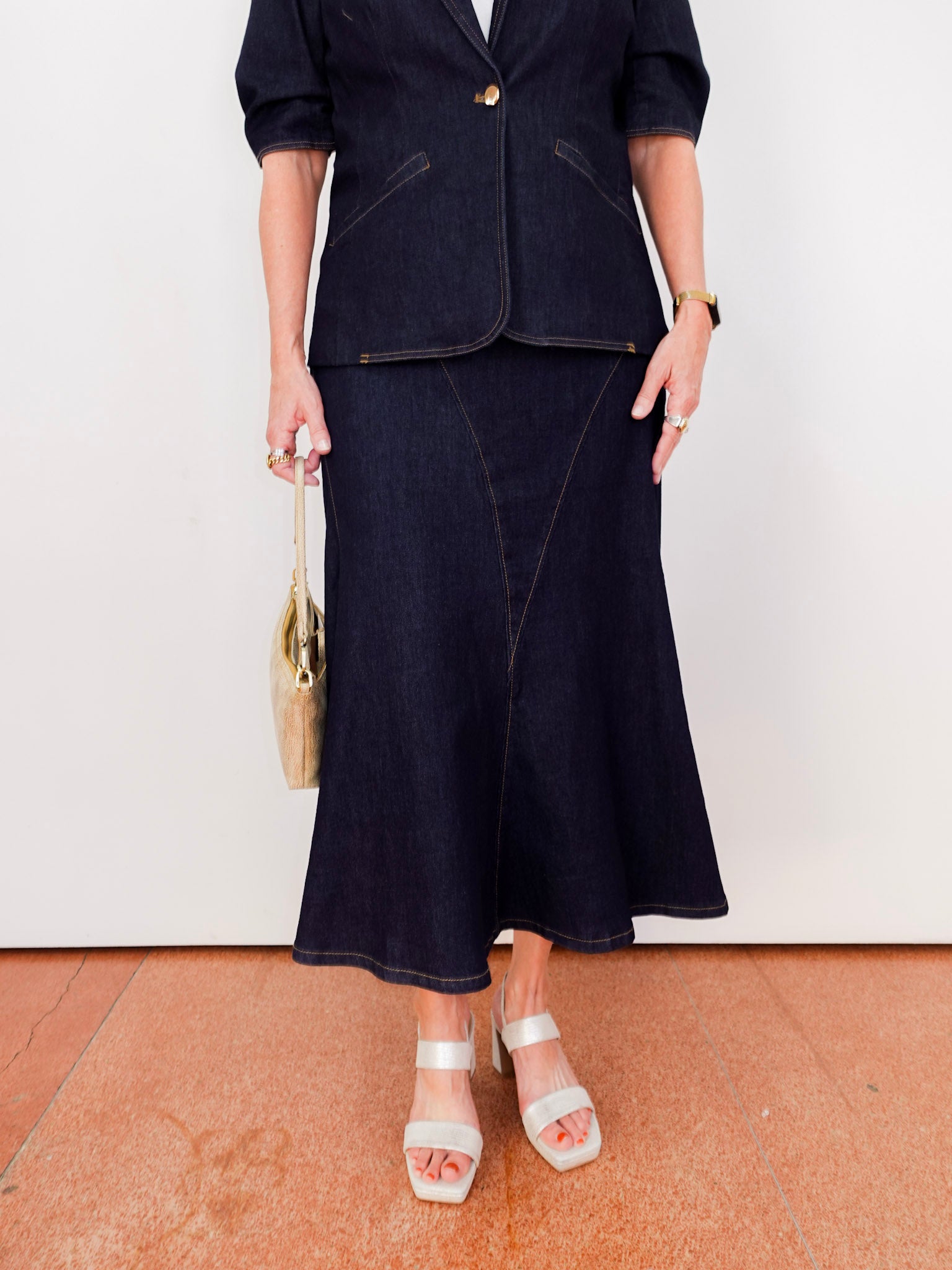 Person wearing a dark blue suit with a white wall background