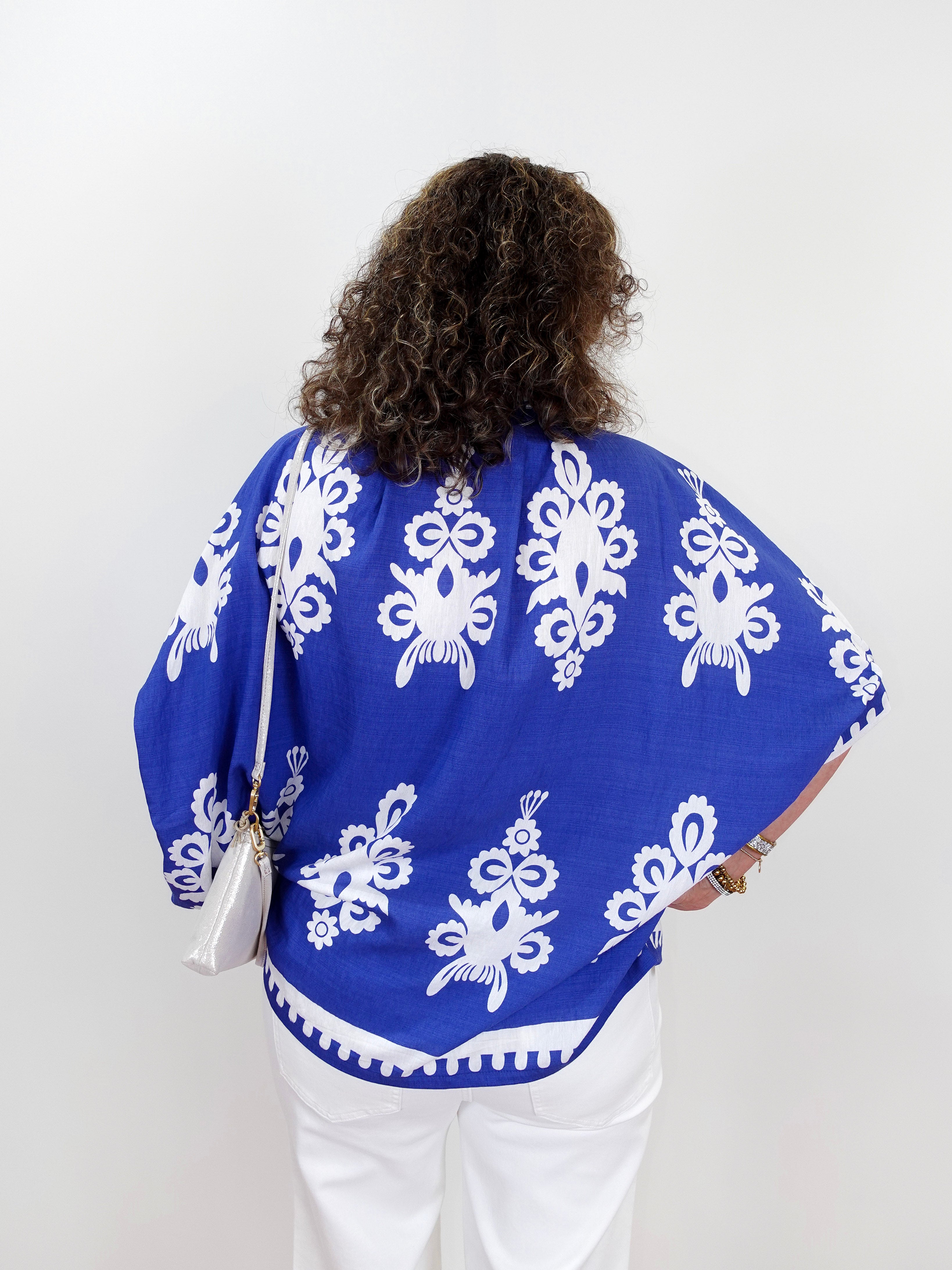 Person wearing a blue patterned top with white background