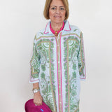 Woman wearing a patterned shirt over a pink top, holding a pink heart-shaped object.