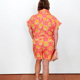 Person wearing a colorful dress with a floral pattern on a white background