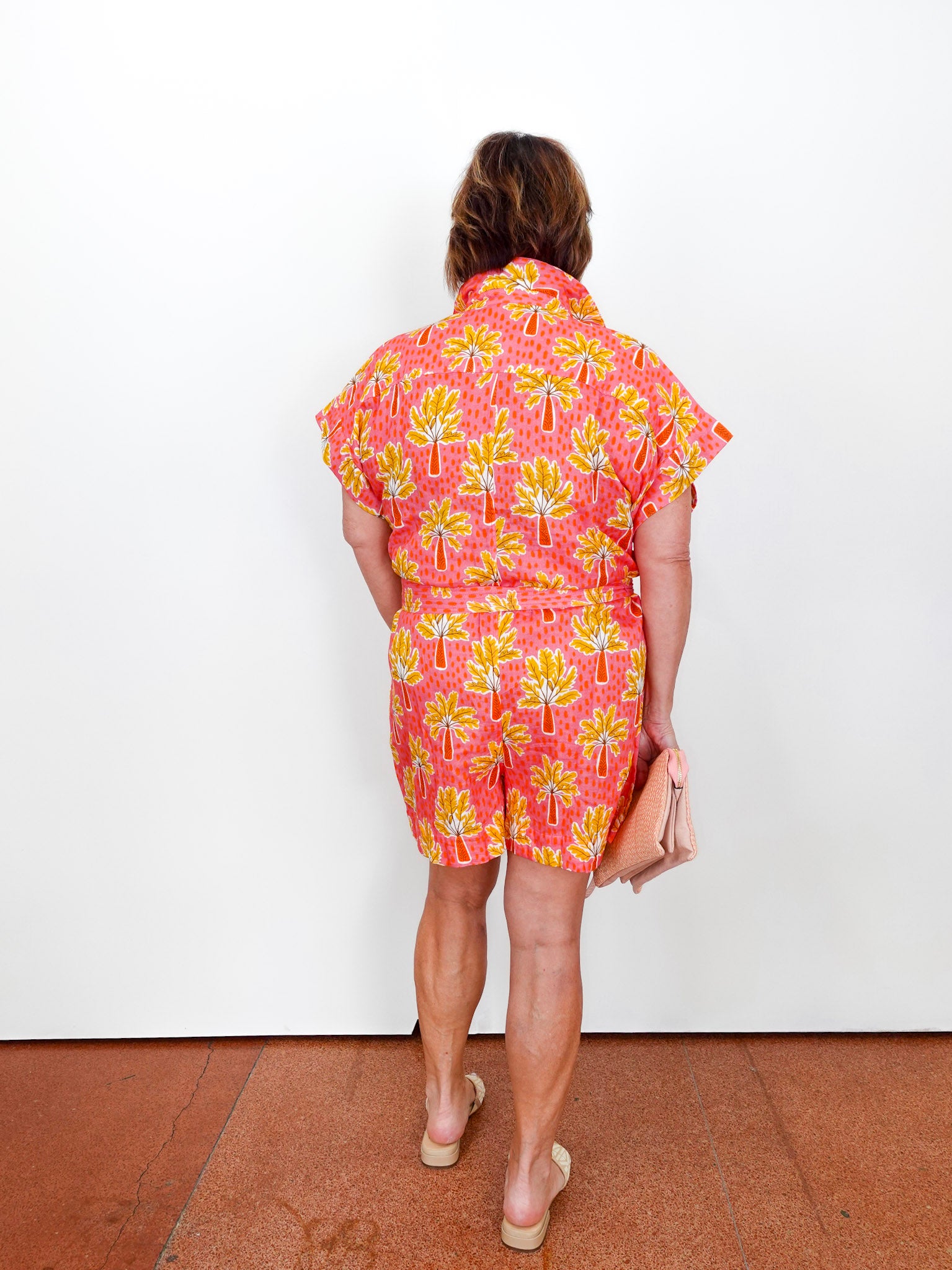 Person wearing a colorful dress with a floral pattern on a white background