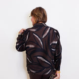 woman wearing a brown blouse against a white background. 