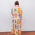 Person wearing a colorful dress with patterned design on a white background