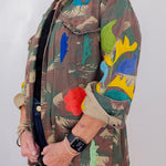 Person wearing a colorful jacket with floral patterns on a plain background