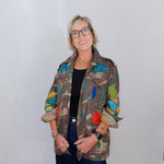 Person wearing a colorful jacket with a plain background